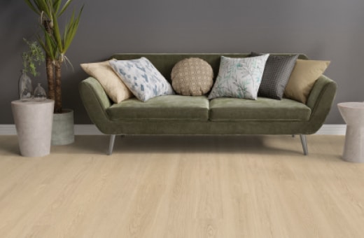 Wohnzimmer mit grünem Sofa und Holzoptikboden