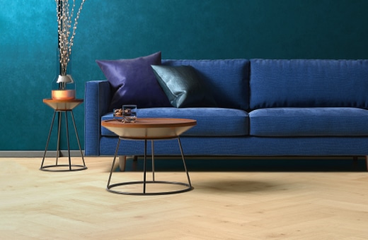 Raum mit blauem Sofa und hellem Vinylboden