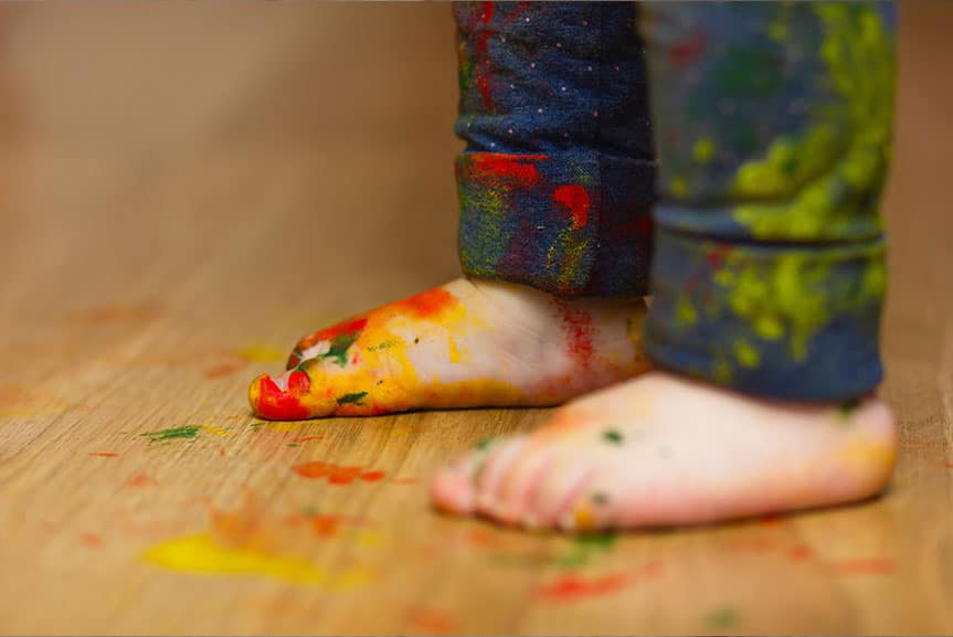 Kinderfüße auf bemaltem Boden – Kreativität und strapazierfähiger Bodenbelag